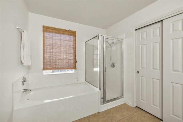 bathroom featuring tile patterned flooring and shower with separate bathtub