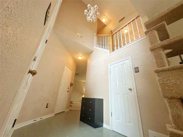 stairway with high vaulted ceiling and a notable chandelier