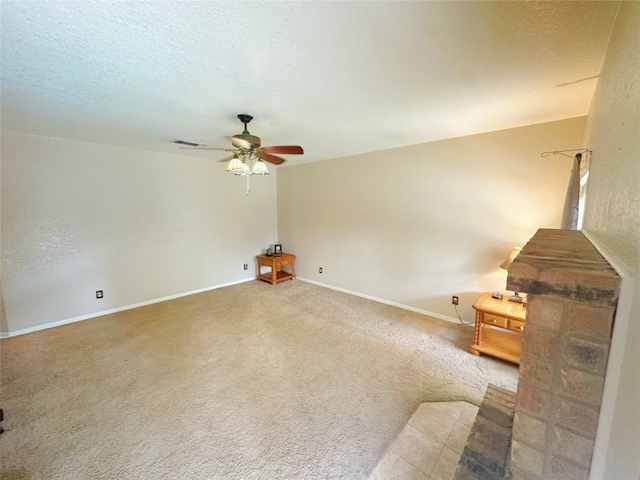 unfurnished living room featuring a textured ceiling, carpet flooring, and ceiling fan