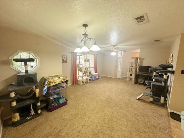 interior space featuring carpet flooring, a textured ceiling, and ceiling fan