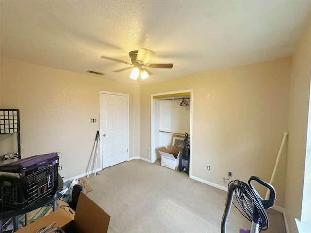 miscellaneous room with ceiling fan, a textured ceiling, and carpet