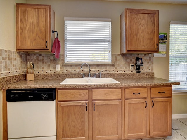 kitchen featuring light tile patterned flooring, sink, white dishwasher, and tasteful backsplash