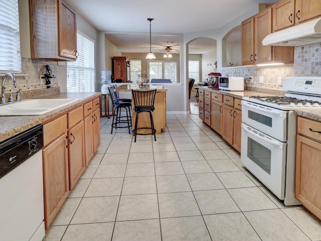 kitchen featuring ceiling fan, pendant lighting, sink, white appliances, and decorative backsplash