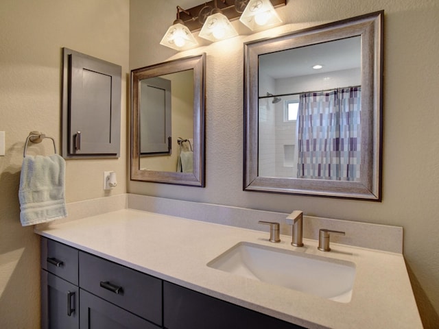 bathroom featuring walk in shower and vanity