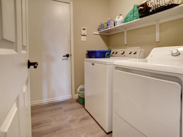 laundry area featuring light wood-type flooring and independent washer and dryer