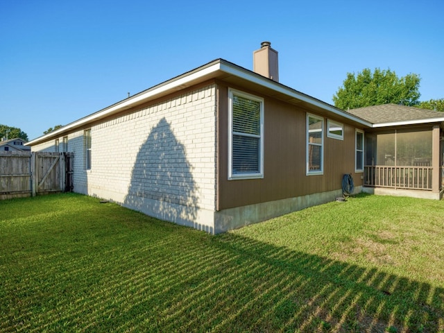 view of side of home with a yard