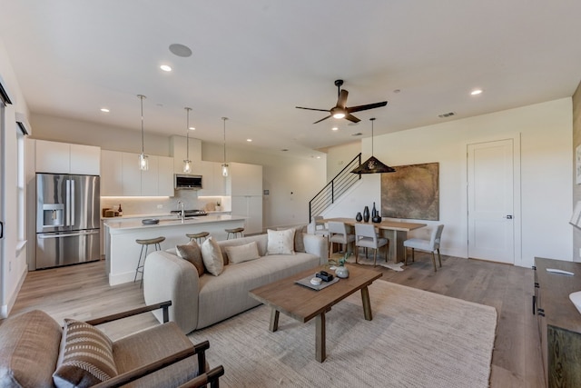 living room featuring ceiling fan and light wood-type flooring