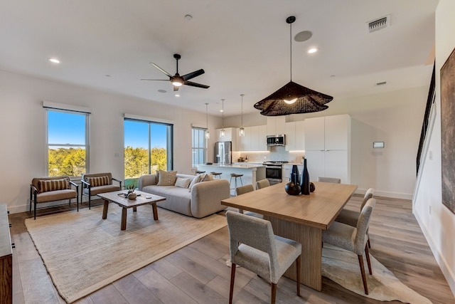 dining space featuring ceiling fan and light wood-type flooring