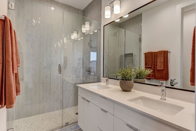 bathroom featuring a shower with door and vanity