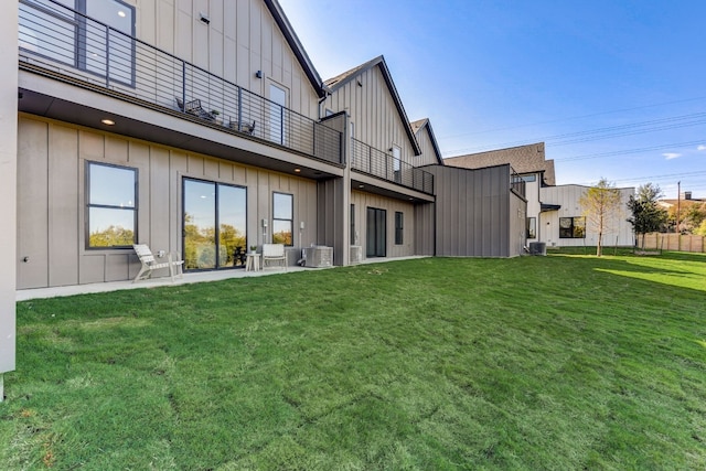 back of property with central air condition unit, a patio area, a balcony, and a lawn