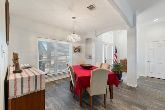 13639 Abrahamson Rd, Manor, TX 78653 - dining area featuring a chandelier, arched walkways, dark wood finished floors, and recessed lighting