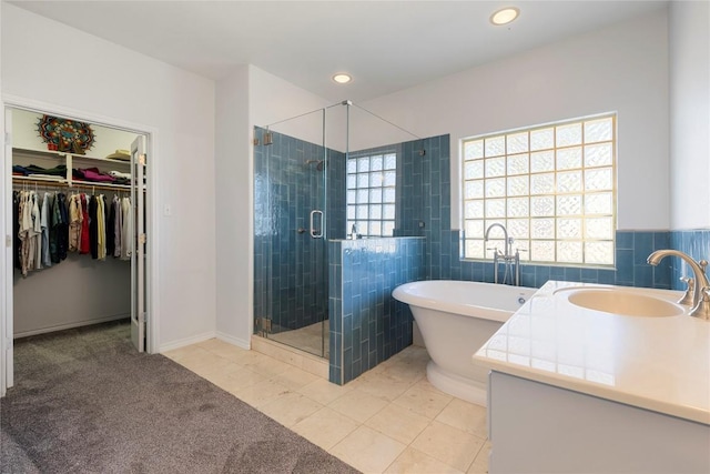 13639 Abrahamson Rd, Manor, TX 78653 - bathroom featuring a shower stall, a freestanding bath, tile walls, a walk in closet, and recessed lighting