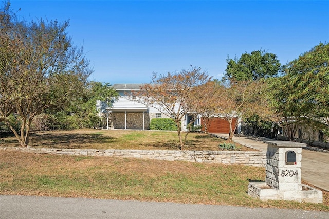 obstructed view of property featuring a front yard