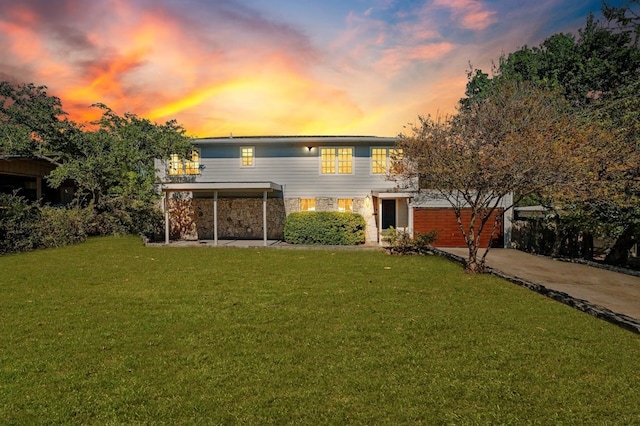 back house at dusk featuring a yard