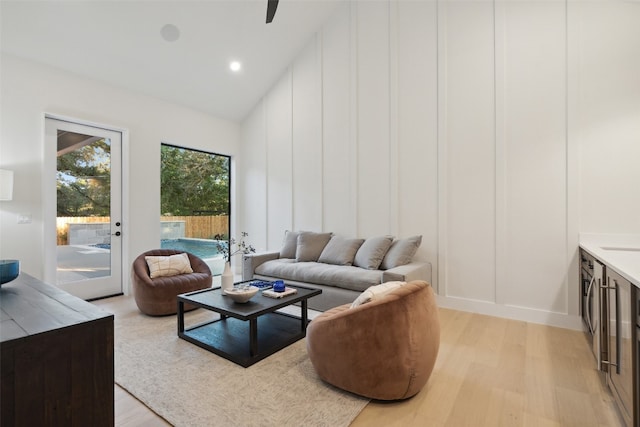 living room featuring light wood-type flooring and high vaulted ceiling