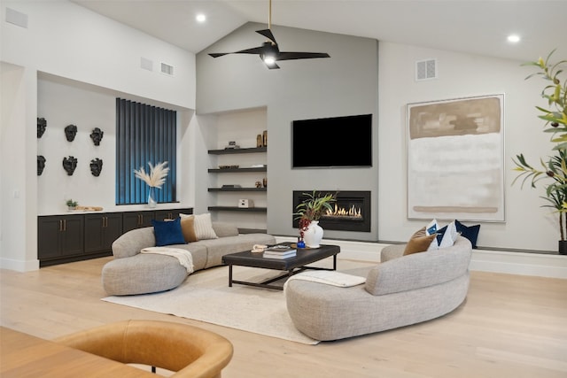 living room featuring ceiling fan, light hardwood / wood-style floors, and high vaulted ceiling