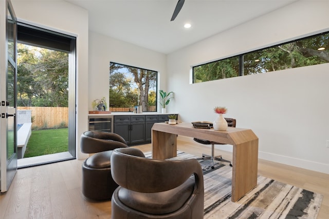 office featuring a healthy amount of sunlight, light wood-type flooring, and wine cooler