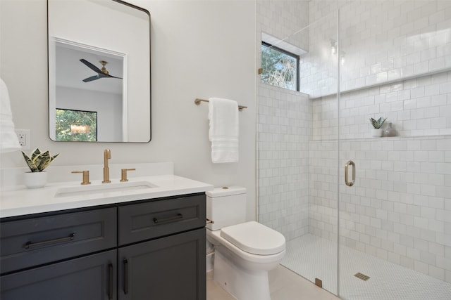 bathroom featuring ceiling fan, tile patterned flooring, toilet, a shower with door, and vanity