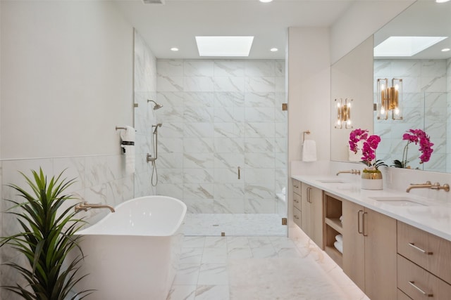 bathroom with vanity, shower with separate bathtub, tile walls, and a skylight