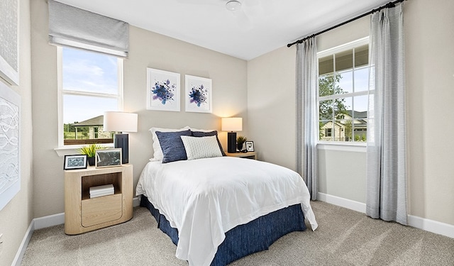 carpeted bedroom with ceiling fan and multiple windows