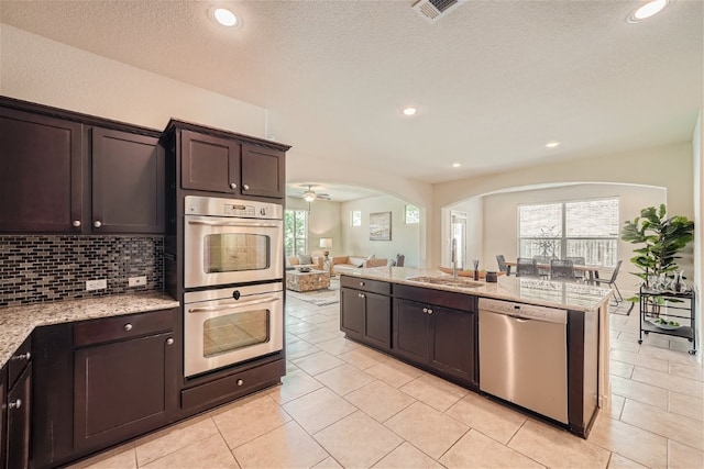 kitchen featuring dark brown cabinets, stainless steel appliances, sink, and ceiling fan