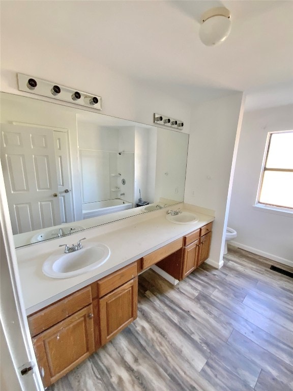 full bathroom with vanity, hardwood / wood-style flooring, toilet, and bathing tub / shower combination