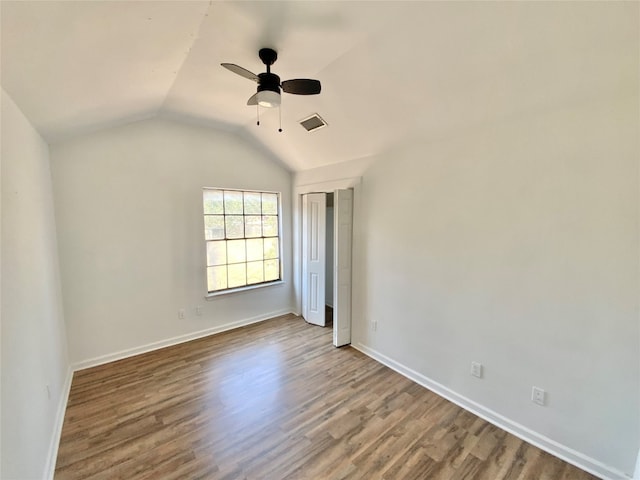 spare room featuring vaulted ceiling, hardwood / wood-style flooring, and ceiling fan