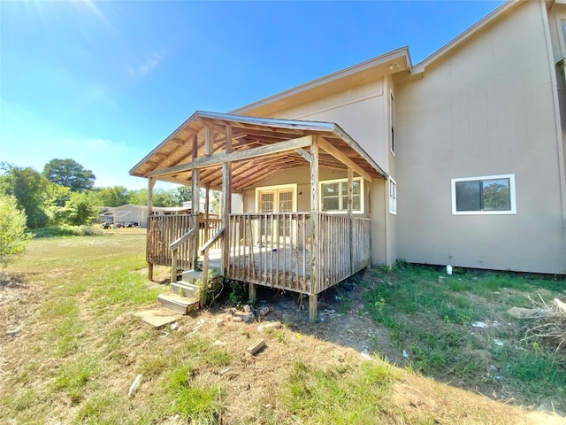 rear view of property featuring a wooden deck and a yard