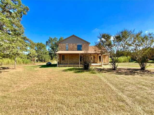 rear view of house featuring a lawn