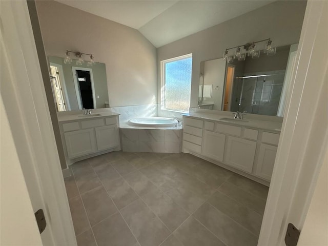 bathroom with tile patterned flooring, vanity, separate shower and tub, and vaulted ceiling