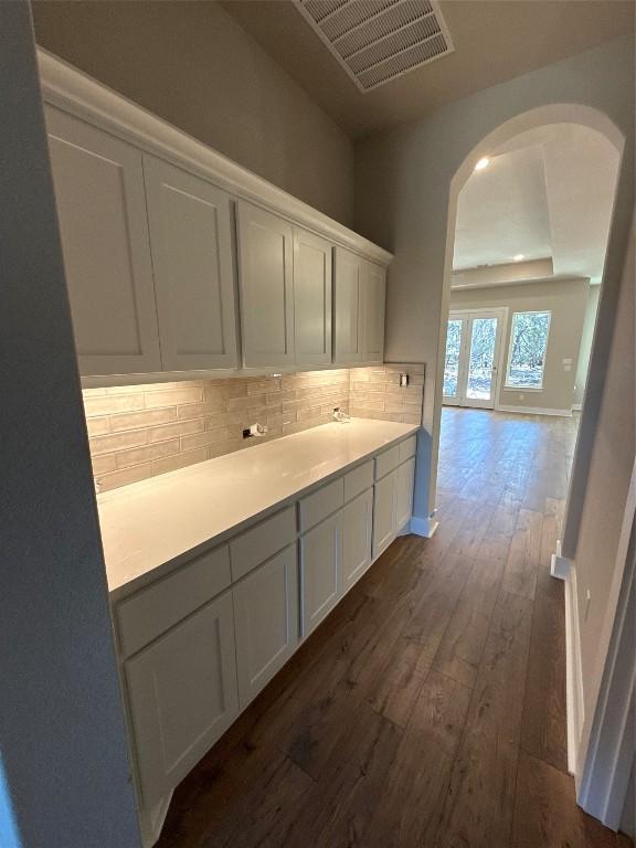 kitchen with tasteful backsplash, white cabinetry, and dark hardwood / wood-style floors