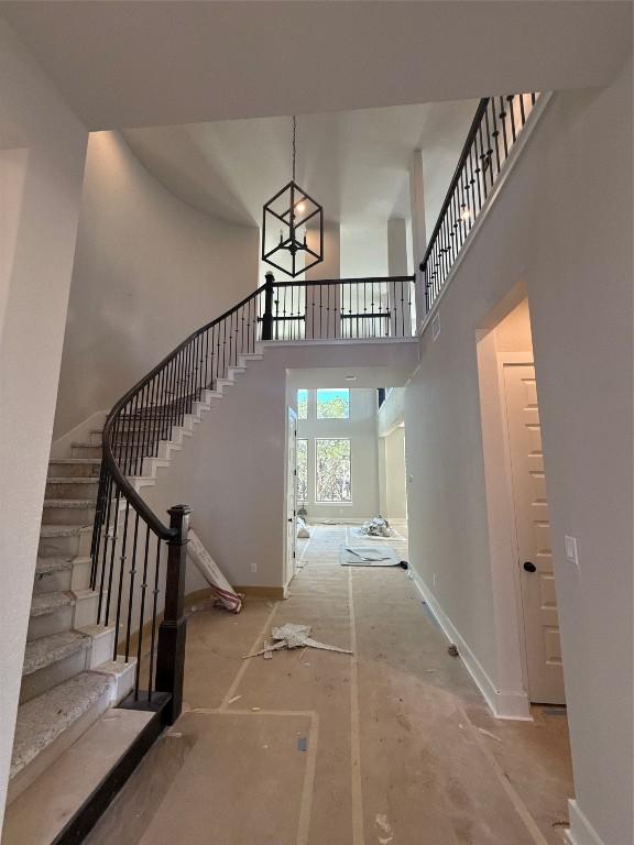 foyer entrance featuring a towering ceiling and concrete floors