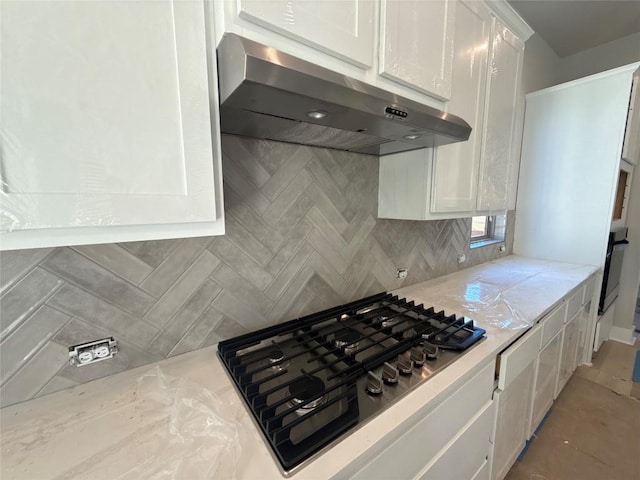 kitchen featuring backsplash, white cabinets, gas stovetop, range hood, and black oven