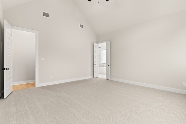 spare room with ceiling fan, light colored carpet, and high vaulted ceiling