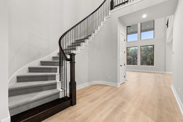 stairs featuring a high ceiling and hardwood / wood-style floors