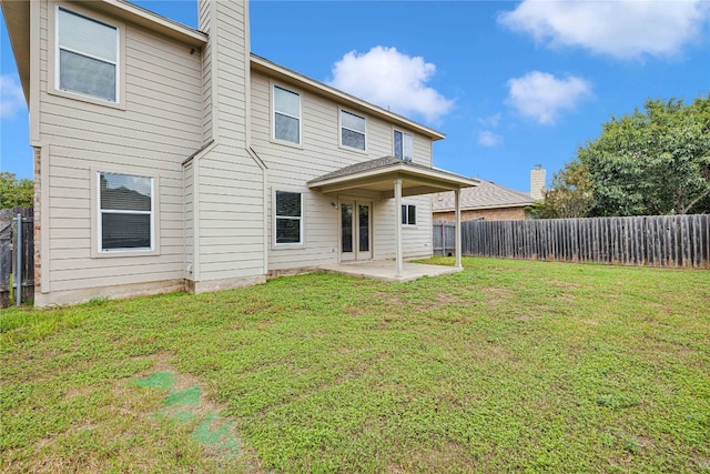 rear view of property featuring a lawn and a patio area