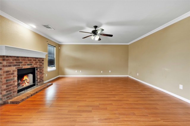 unfurnished living room with light hardwood / wood-style floors, a fireplace, ornamental molding, and ceiling fan