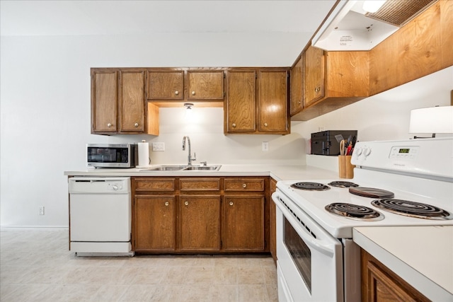 kitchen featuring ventilation hood, white appliances, and sink