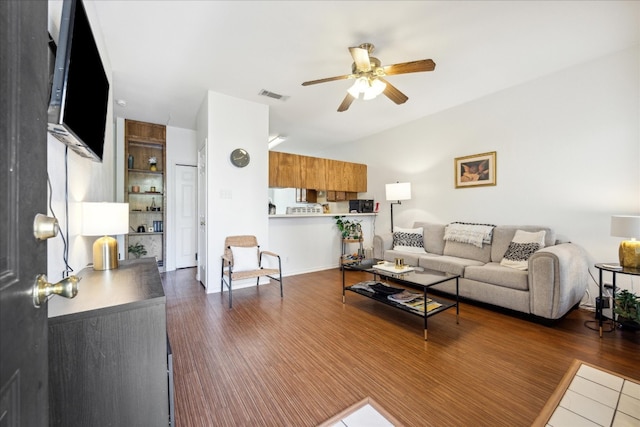 living room with ceiling fan and dark wood-type flooring