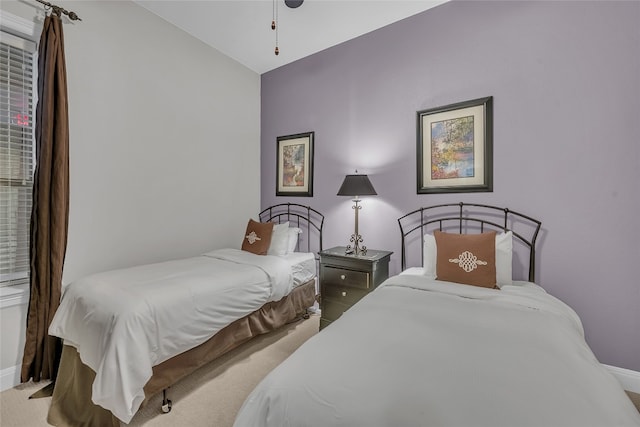 bedroom with light colored carpet and vaulted ceiling