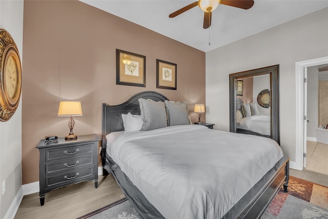 bedroom with light hardwood / wood-style floors, ensuite bath, and ceiling fan