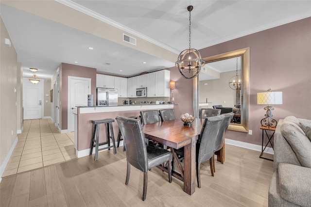 dining room with light hardwood / wood-style flooring and crown molding