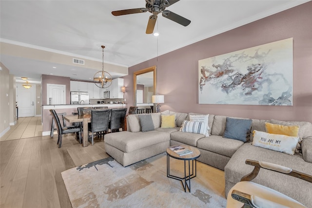 living room with ceiling fan with notable chandelier, light wood-type flooring, and crown molding