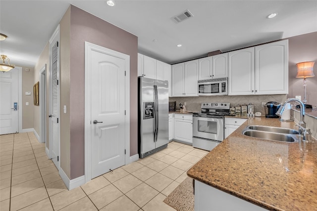 kitchen featuring light tile patterned floors, white cabinets, appliances with stainless steel finishes, and sink