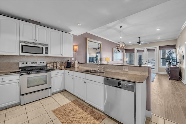 kitchen featuring white cabinetry, kitchen peninsula, appliances with stainless steel finishes, and sink