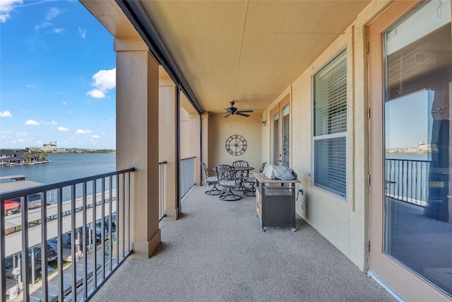 balcony featuring a water view and ceiling fan