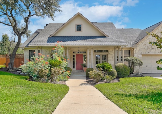 view of front of home featuring a front lawn, a porch, and a garage