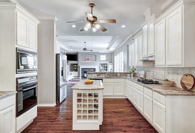 kitchen with black oven, gas cooktop, high quality fridge, a kitchen island, and built in microwave