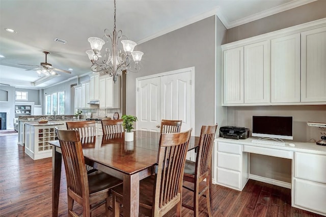 dining area with dark wood-type flooring, ornamental molding, and built in desk