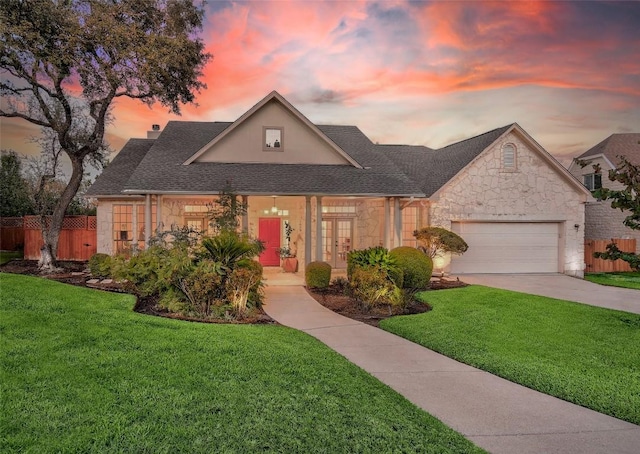 view of front of property featuring a garage and a lawn